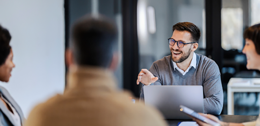 team meeting around table with laptops